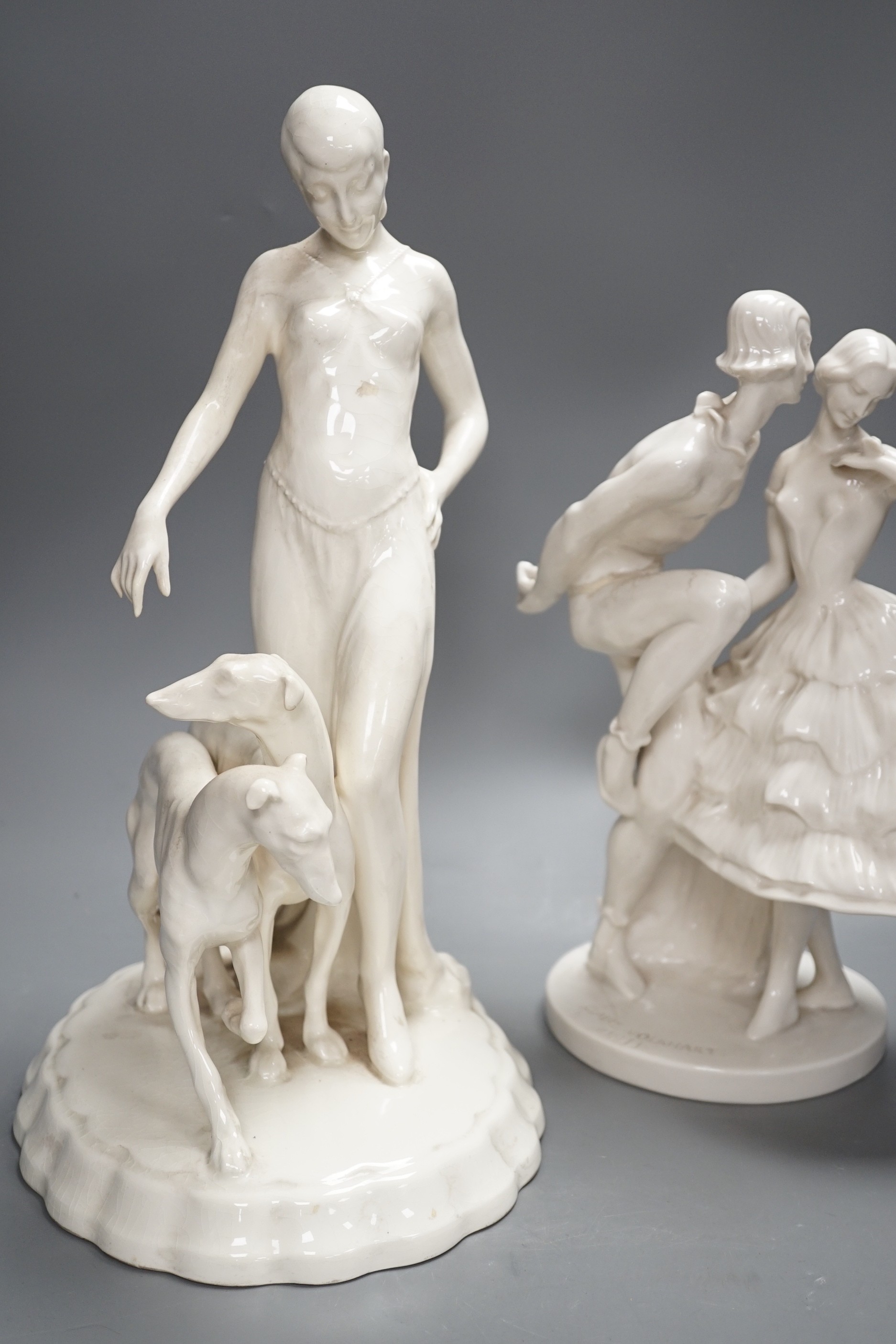 A Royal Dux Art Deco white glazed group modelled as a flapper with two greyhounds, no. 14212, and a Schwarzberger Werkstatten for Porzellankunst group modelled by Claire Volkhart Tallest 41cm